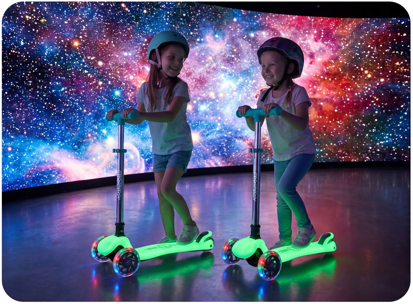 Divi bērni ar ķiverēm brauc ar Ricokids Glow skrejriteņiem, redzami izgaismoti riteņi un kustības aina