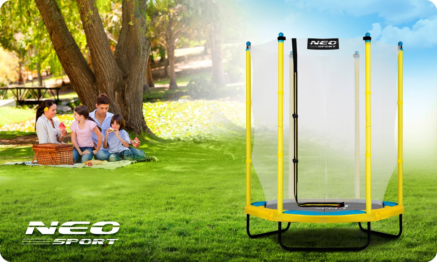 Neo-Sport bērnu batuts 140 cm parkā uz zāliena ar ģimeni piknikā fonā