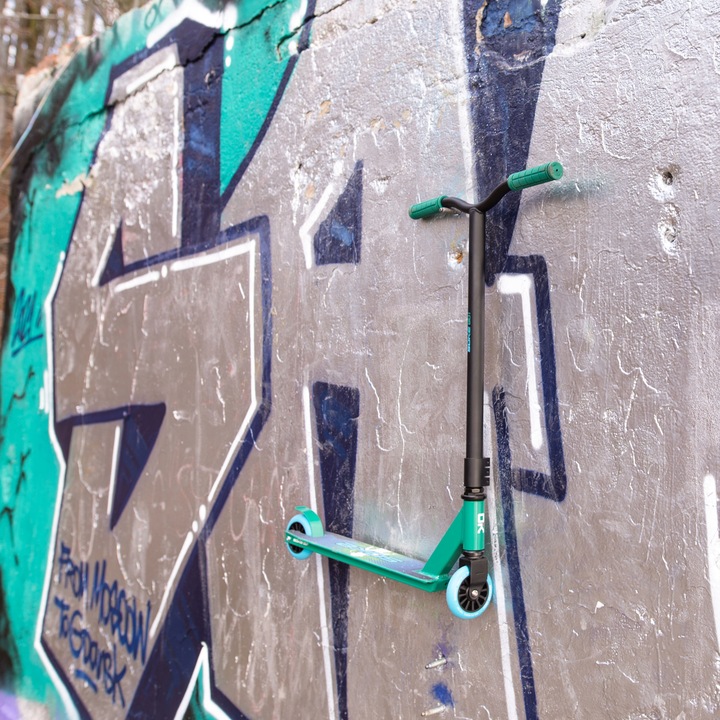 SOKE GO! triku skrejritenis atspiedies pret grafiti sienu, redzams augsts stūres stienis