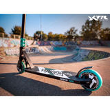 SOKE XTR Phantom triku skrejritenis no sāna skateparkā, redzams deck, stūre un aizmugurējais ritenis
