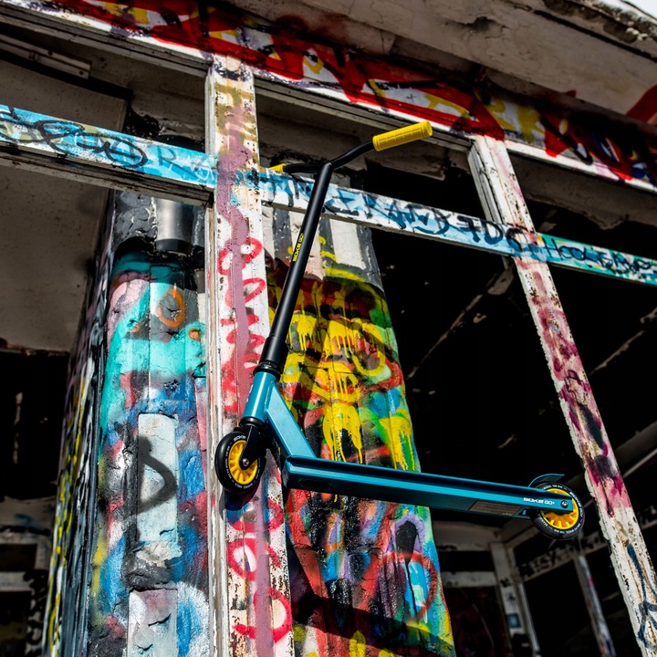 SOKE GO! skrejritenis pilnā garumā pie grafiti ēkas
