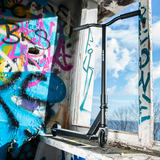 SOKE GO! triku skrejritenis pie grafiti sienas ar skatu uz rāmi un priekšējo daļu