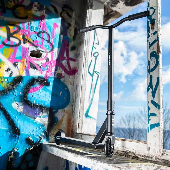 SOKE GO! triku skrejritenis pie grafiti sienas un loga malas