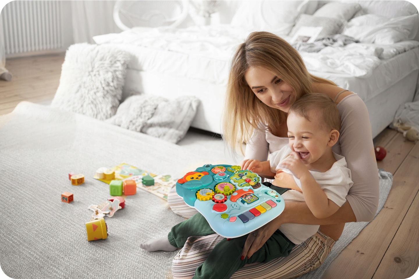 Bērns un pieaugušais rotaļājas ar noņemamo Ricokids izglītojošo paneli istabas vidū