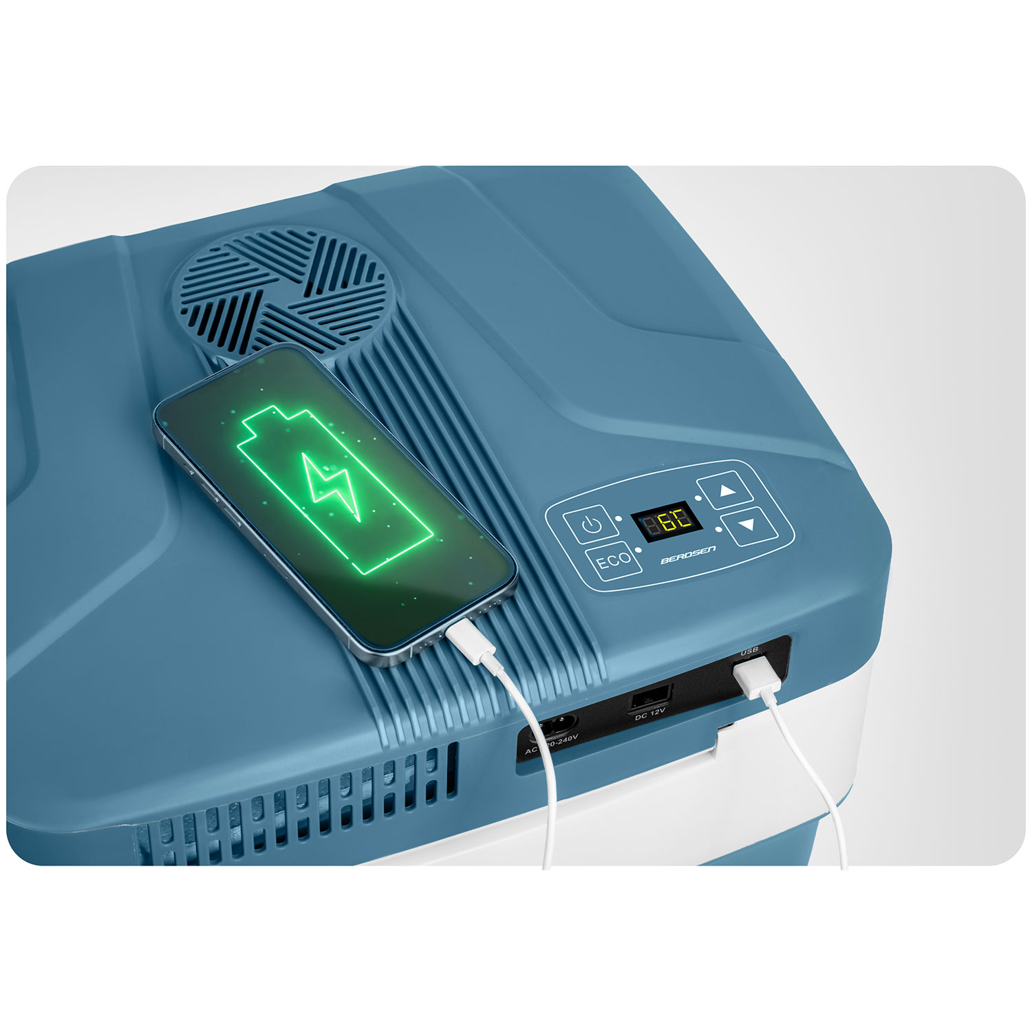 Tūristu ledusskapja augšējais tuvplāns ar pieslēgtu telefonu, USB uzlādi un ventilācijas režģi
