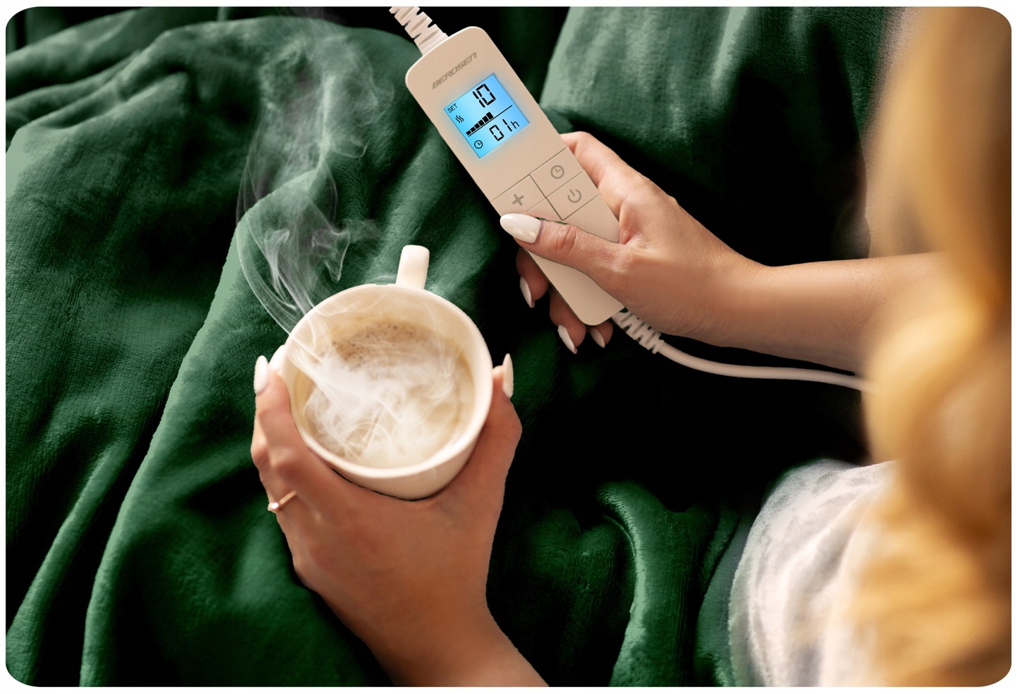 Roka tur elektriskās segas vadības pulti virs zaļas segas