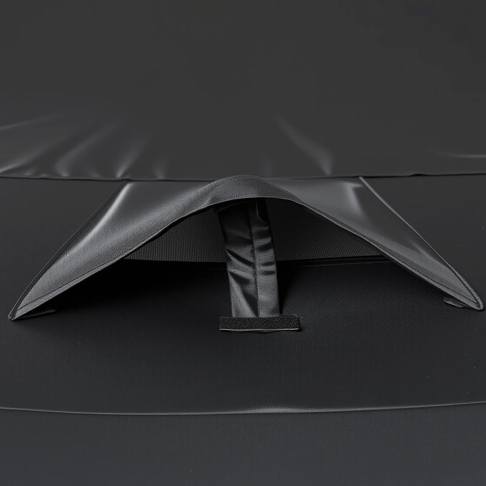 Ledus makšķerēšanas telts ventilācijas atveres tuvplāns melnā auduma virsmā